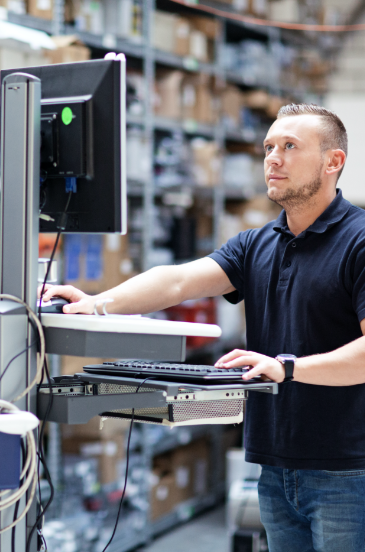 Man working at a computer in a warehouse